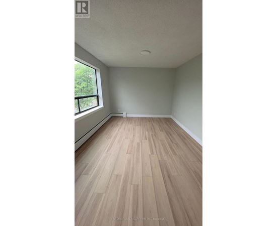 A room with wooden flooring and a window.