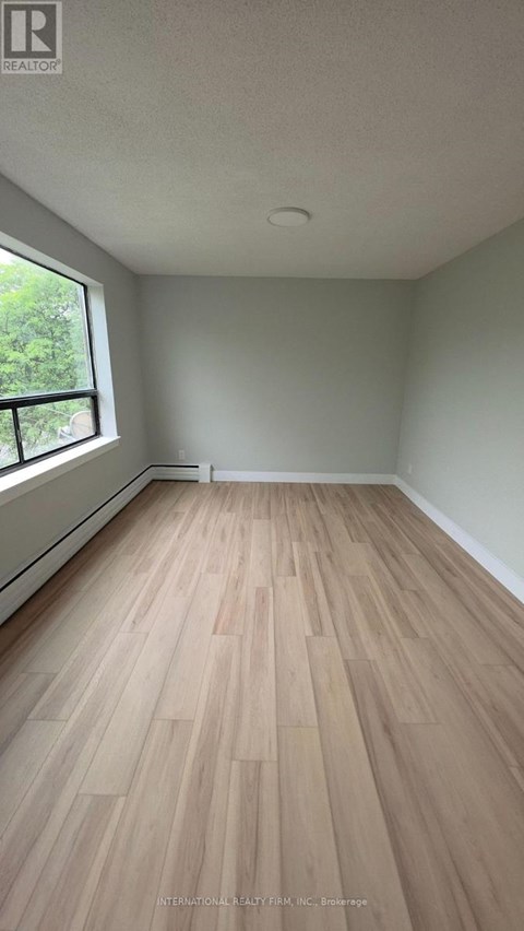 A room with wooden flooring and a window.