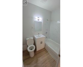 A white toilet sits next to a sink in a small bathroom.