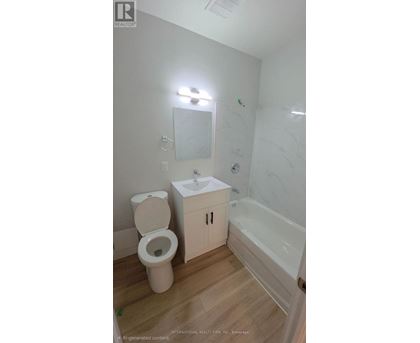 A white toilet sits next to a sink in a small bathroom.