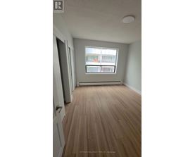A room with wooden flooring and a window.