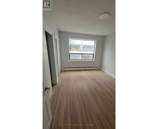 A room with wooden flooring and a window.