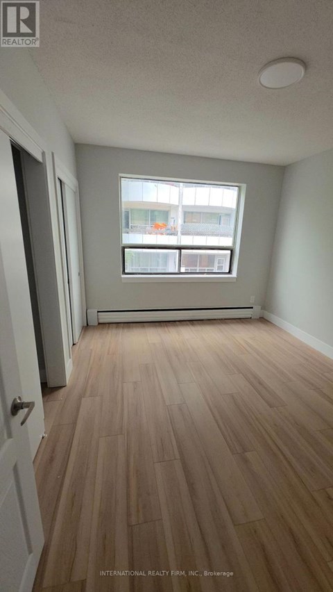 A room with wooden flooring and a window.