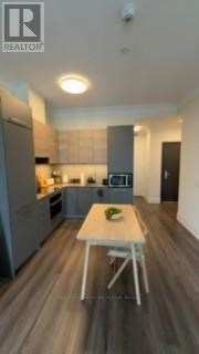 A modern kitchen with a table and chairs in the middle.