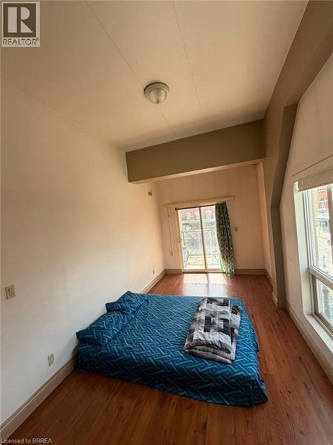 A bedroom with a bed covered in a blue blanket.