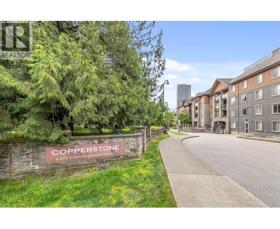 A street view of the Copperstone residential area with apartment buildings on the right and a sign on the left.