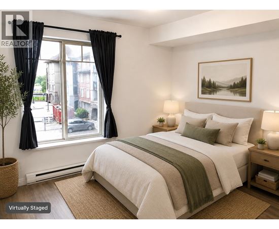 A bedroom with a large bed and a window with black curtains.