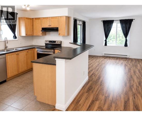 A kitchen with wooden cabinets and a black countertop.