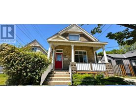 A small house with a red door is for sale.