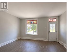 A room with a white door and a window with a stained glass design.