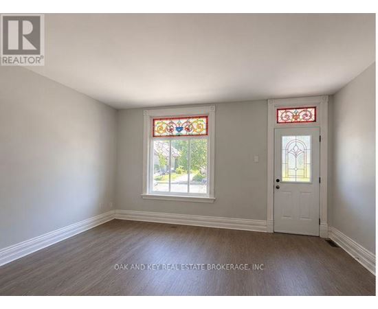 A room with a white door and a window with a stained glass design.