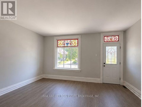 A room with a white door and a window with a stained glass design.