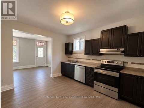 A kitchen with dark brown cabinets and stainless steel appliances.