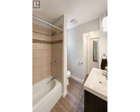 A bathroom with a tub, toilet, and sink.
