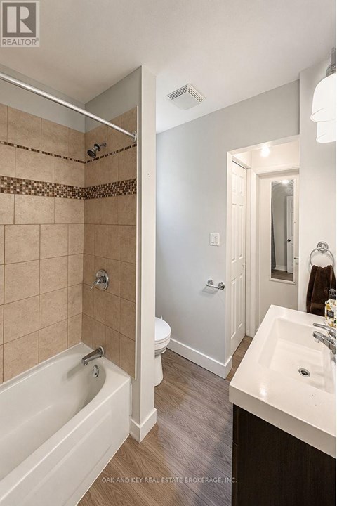 A bathroom with a tub, toilet, and sink.