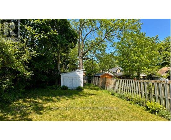 A white shed sits in a grassy yard.