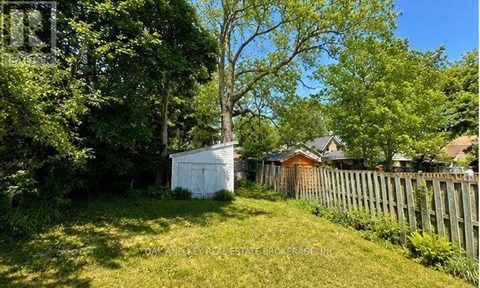 A white shed sits in a grassy yard.