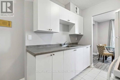 A kitchen with white cabinets and a counter top.