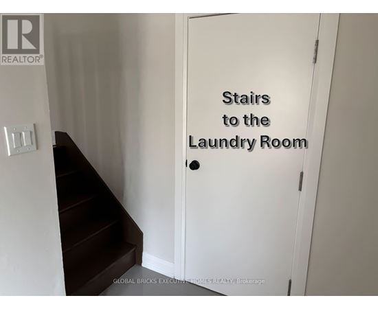 A white door with a sign that says "Stairs to the Laundry Room".
