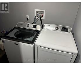 A Global Bricks Executive Homes Realty brochure is displayed on a wall above a washer and dryer.