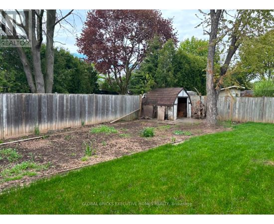 A backyard with a wooden fence and a small shed.
