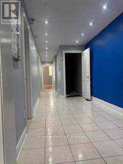 A long hallway with white tile floors and blue walls.