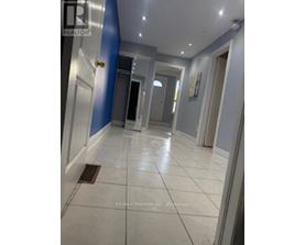 A hallway with a tiled floor and a blue wall on the left.