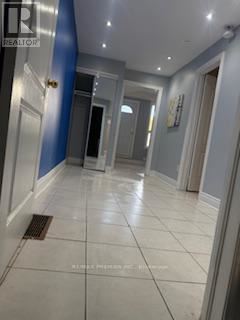 A hallway with a tiled floor and a blue wall on the left.