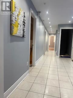 A hallway with a painting on the wall and a door at the end.