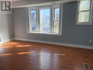 A room with a large window and wooden flooring.