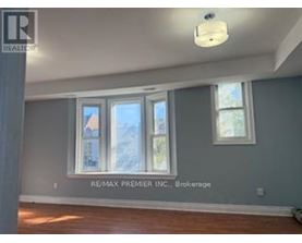 A room with a window and a sign that says RE/MAX Premier Inc. Brokerage.
