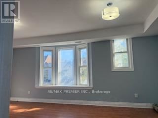 A room with a window and a sign that says RE/MAX Premier Inc. Brokerage.