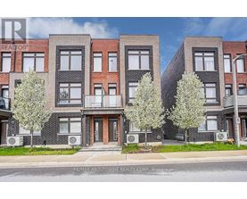 A row of townhouses with trees in front of them.