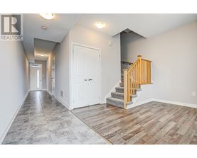 A hallway with a staircase and two doors.