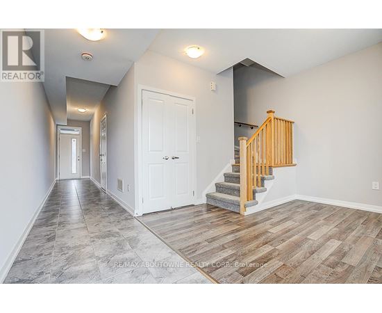 A hallway with a staircase and two doors.