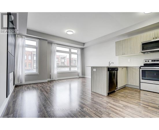 A spacious kitchen with a refrigerator, oven, and microwave.