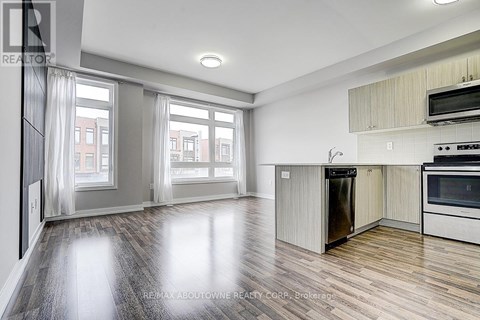 A spacious kitchen with a refrigerator, oven, and microwave.