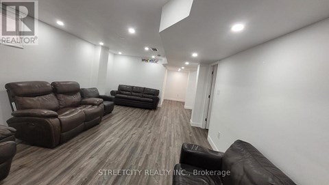 A living room with brown leather couches and a wooden floor.