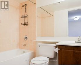 A bathroom with a tub, toilet, and sink.