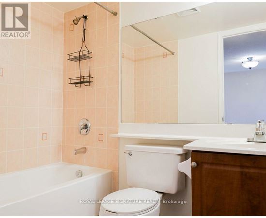 A bathroom with a tub, toilet, and sink.