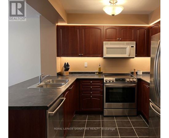 A kitchen with brown cabinets and a stainless steel oven.