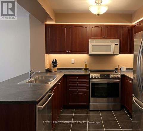 A kitchen with brown cabinets and a stainless steel oven.