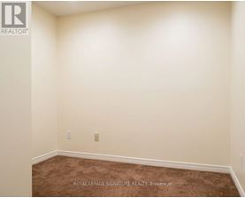 A room with a carpet floor and a white wall.