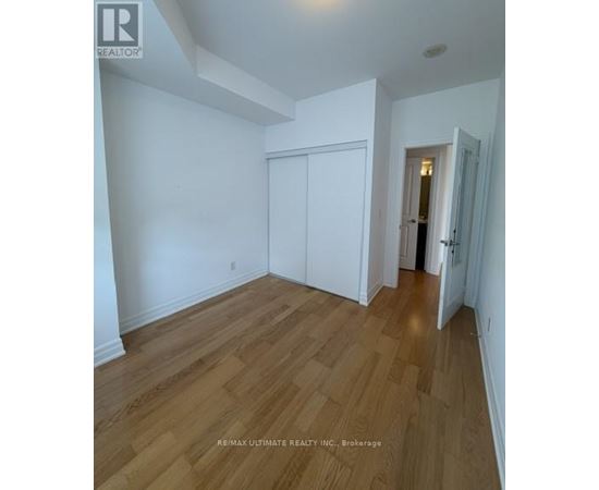 A room with wood flooring and white walls.