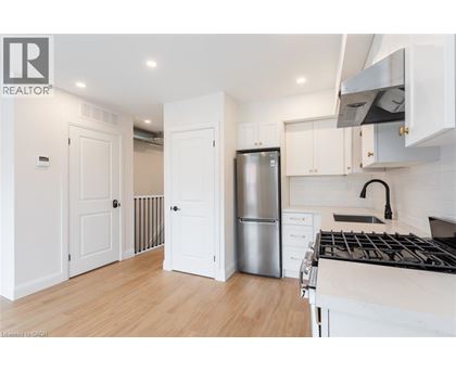 A modern kitchen with white cabinets and a stainless steel refrigerator.