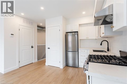 A modern kitchen with white cabinets and a stainless steel refrigerator.