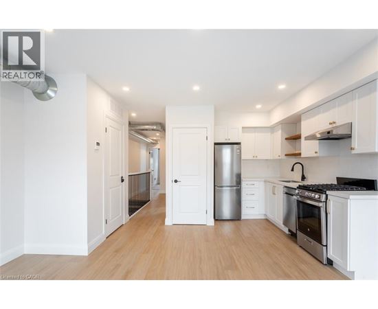A modern kitchen with white cabinets and stainless steel appliances.