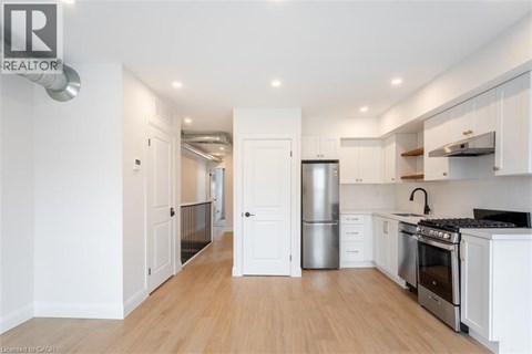 A modern kitchen with white cabinets and stainless steel appliances.
