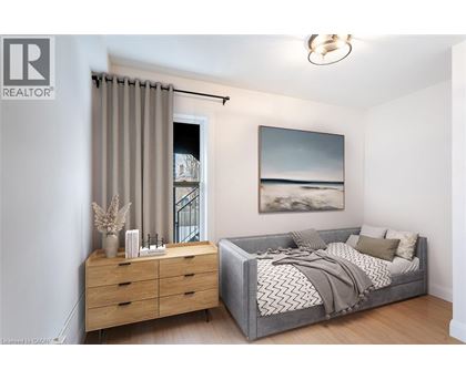 A bedroom with a bed, dresser, and a painting on the wall.