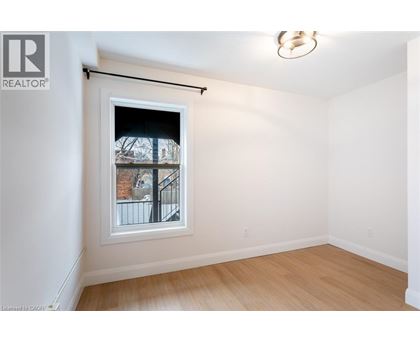A room with a window showing a view of a building outside.